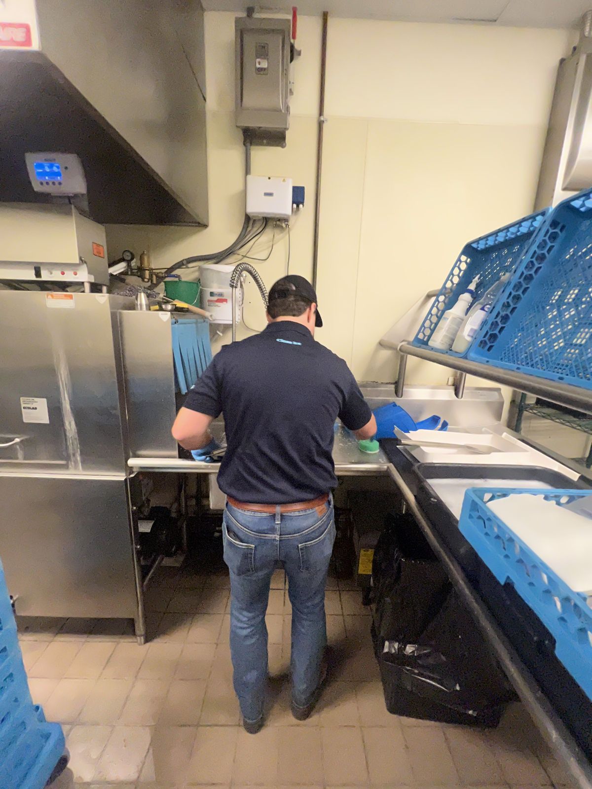 Technician deep cleaning the interior of a stainless steel commercial ice machine